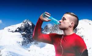 Young man jogging outside in sunny winter mountains